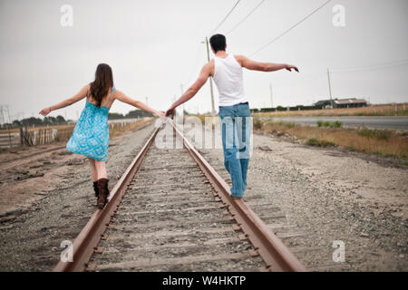 Jeune couple en équilibre sur les voies de train ensemble Banque D'Images
