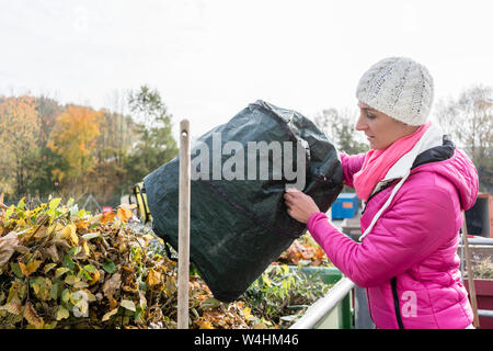 Femme donnant dans le récipient à déchets green recycling center Banque D'Images