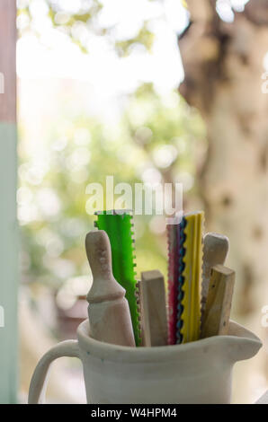 Vue verticale de divers outils en bois Poterie près d'une fenêtre sur un matin ensoleillé. Concept connexes poterie Banque D'Images