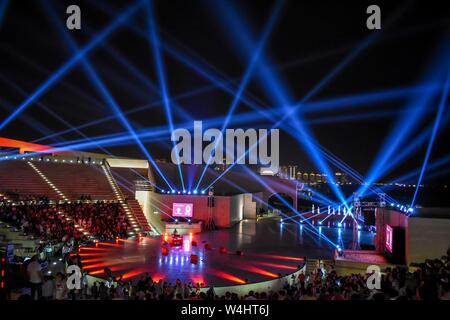 Spectacle sur la scène de l'amphithéâtre au Katara Cultural Village à Doha, Qatar, la nuit, avec des faisceaux lumineux brillants à travers le ciel sombre. Banque D'Images