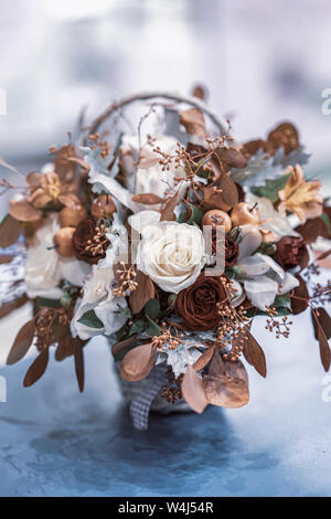 Bouquet de feuilles d'automne, les baies roses, dans des teintes d'automne, fleurs d'automne dans le rustique panier en osier Banque D'Images