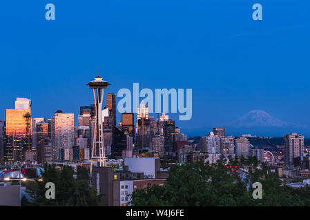 Le Seattle Skyline de Kerry Park par des réflexions de l'orange et rose coucher du soleil dans le verre des gratte-ciel avec le Mont Rainier dans la distance Banque D'Images