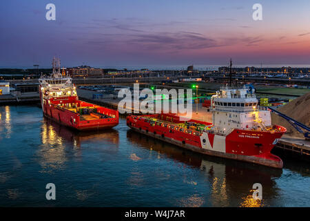 Deux navires déchargent en quais Zeebrugge au coucher du soleil. avec reflets dans l'eau Banque D'Images