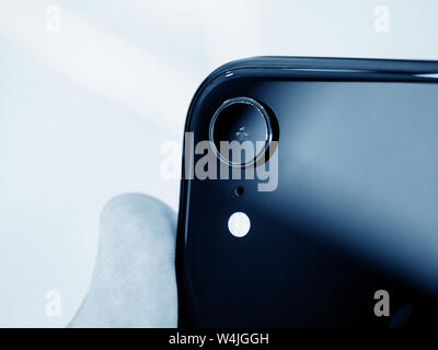 Paris, France - 26 octobre 2018 : Man hand holding dernier iPhone XR doté d'une caméra Vue arrière AR avec une lentille unique image en noir et blanc Banque D'Images