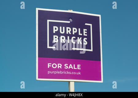 Un purplebricks signe indiquant une propriété est à vendre par l'agence immobilière en ligne. Banque D'Images