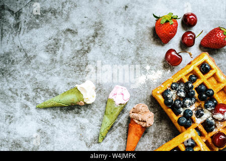 Fond d'aliments sucrés et savoureux avec des fruits rouges et des gaufres, avec l'espace négatif pour la conception d'été. Banque D'Images