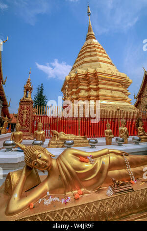 Inclinaison et statues de Bouddha Doré assis et temple stupa au Wat Phra That Doi Suthep complexe dans Chiang Mai, Thaïlande du Nord. Banque D'Images