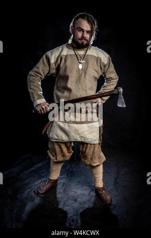 Viking dans les tenues de tenir une hache dans ses mains. La reconstruction historique de l'époque médiévale précoce Banque D'Images