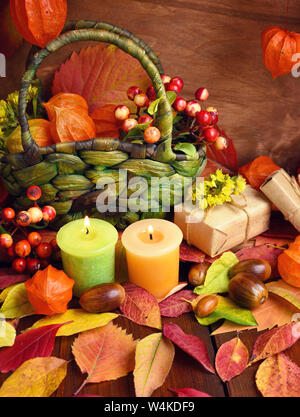 Toujours agréable d'automne de la vie. Des bougies, des baies, des feuilles de l'automne et physalis sur fond de bois. Banque D'Images