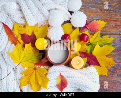 Composition d'automne. Tasse de café, des feuilles colorées, des bougies et un foulard sur fond de bois. Vue d'en haut. Banque D'Images
