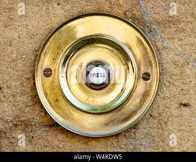 Une porte en bronze circulaire push bell à Chipping Campden, Cotswolds, Gloucestershire, Angleterre, Royaume-Uni, Grande Bretagne, FR, UK. Banque D'Images