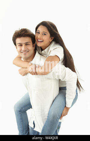 Indian woman riding piggyback sur son mari et smiling Banque D'Images