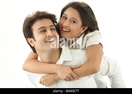 Indian woman riding piggyback sur son mari et smiling Banque D'Images