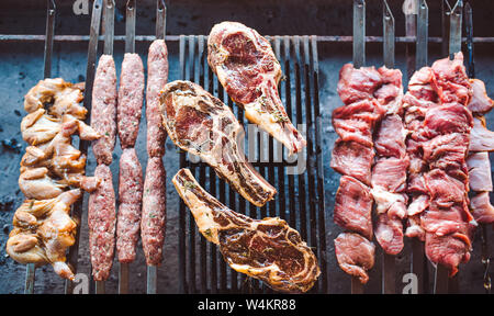 De grands morceaux de viande marinés sur une grille dans un restaurant. Grillades mixtes Banque D'Images