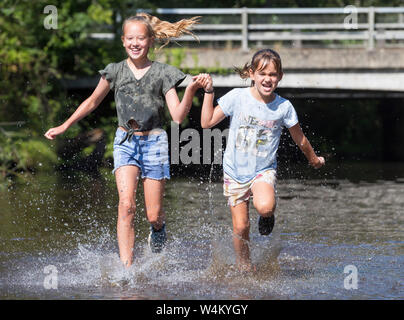 New Forest, Hampshire 24 juillet 2019. Météo France : Soeurs Ebony 11 Isobella 8 et vous rafraîchir dans la rivière à Brockenhurst dans la nouvelle forêt que le temps chaud continue à travers le Royaume-Uni. Stuart Martin Crédit/Alamy Live News Banque D'Images