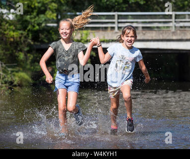 New Forest, Hampshire 24 juillet 2019. Météo France : Soeurs Ebony 11 Isobella 8 et vous rafraîchir dans la rivière à Brockenhurst dans la nouvelle forêt que le temps chaud continue à travers le Royaume-Uni. Stuart Martin Crédit/Alamy Live News Banque D'Images