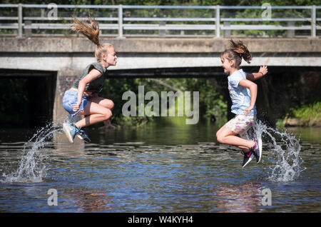 New Forest, Hampshire 24 juillet 2019. Météo France : Soeurs Ebony 11 Isobella 8 et vous rafraîchir dans la rivière à Brockenhurst dans la nouvelle forêt que le temps chaud continue à travers le Royaume-Uni. Stuart Martin Crédit/Alamy Live News Banque D'Images