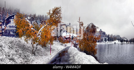 Vue panoramique de l'automne avec la première neige sur une route mouillée de saleté dans les montagnes, arbres et forêt, dans la neige et le givre sur l'arrière-plan d'un overcas Banque D'Images