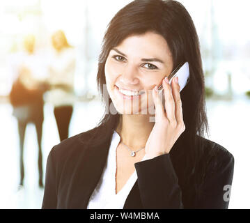 Business femme parle au téléphone dans l'arrière-plan le travail d'équipe dans le bureau Banque D'Images