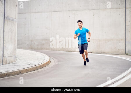 L'homme athlétique durant la course Sprint session dans la ville Banque D'Images