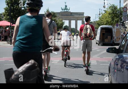 Berlin, Allemagne. 24 juillet, 2019. E-scooters et des cyclistes rencontrez un feu rouge en face de la porte de Brandebourg. Credit : Jörg Carstensen/dpa/Alamy Live News Banque D'Images