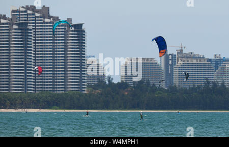 La Chine, la province de Hainan. 24 juillet, 2019. Kite surfeurs sont vus sur la mer de Chine du sud, province de Hainan, le 24 juillet 2019. En été, le magnifique paysage côtier de Rhodos attire de nombreux touristes. Crédit : Yang Guanyu/Xinhua/Alamy Live News Banque D'Images