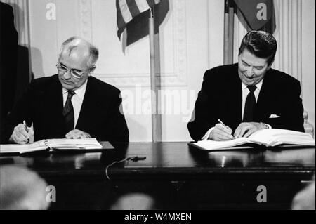 Le président des États-Unis Ronald Reagan et le Secrétaire général soviétique Mikhaïl Gorbatchev signant sur les forces nucléaires à portée intermédiaire (Traité FNI) le 8 décembre 1987 dans l'East Room de la Maison Blanche. Banque D'Images