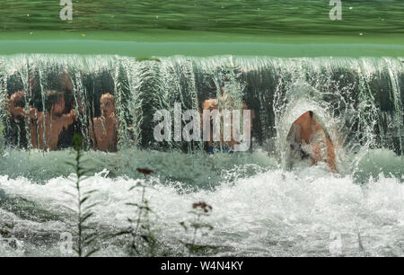 Munich, Allemagne. 24 juillet, 2019. Les enfants jouent à une petite cascade dans le jardin anglais de l'Eisbach. Crédit : Peter Kneffel/dpa/Alamy Live News Banque D'Images