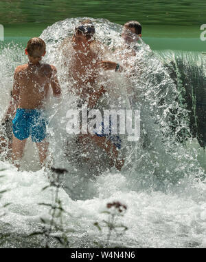 Munich, Allemagne. 24 juillet, 2019. Les enfants jouent à une petite cascade dans le jardin anglais de l'Eisbach. Crédit : Peter Kneffel/dpa/Alamy Live News Banque D'Images