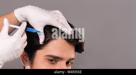 La mésothérapie de cheveux. Jeune homme s'injections dans head Banque D'Images