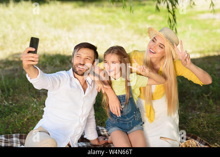 Cheerful family making parc extérieur dans selfies Banque D'Images