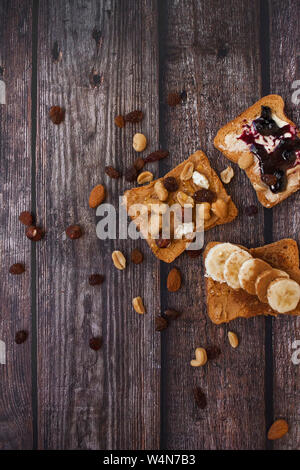 Close-up du matin, toasts avec différents types de garnitures sur fond de bois. Banque D'Images