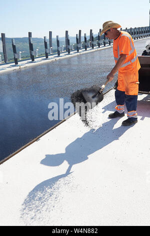 Zeltingen Rachtig, Allemagne. 24 juillet, 2019. L'asphaltage des travailleurs la surface de la route de l'Hochmosel bridge en construction à des températures bien au-dessus de 30 degrés Celsius. Il n'est pas ombragée sur les 160 mètres de haut au-dessus de la vallée de la Moselle. Crédit : Thomas Frey/dpa/Alamy Live News Banque D'Images