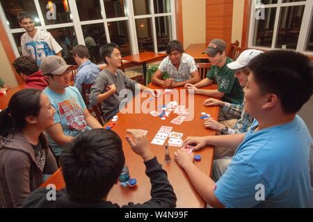 Capture d'un grand angle d'un groupe d'étudiants, assis autour d'une longue table en bois et jouer au poker, à la Johns Hopkins University, Baltimore, Maryland, le 21 septembre 2006. À partir de la collection photographique de Homewood. () Banque D'Images