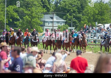 Les spectateurs, à l'extérieur par une journée ensoleillée, regarder les jockeys montent leurs chevaux de course autour de la piste sur le Preakness journée au Pimlico Race Course, Baltimore, Maryland, le 20 mai 2006. À partir de la collection photographique de Homewood. () Banque D'Images