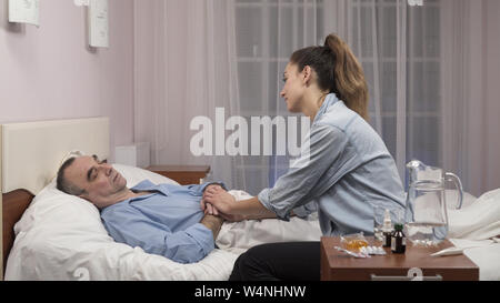 Fille visiter vieux père à l'hôpital et de la santé pour leur parler de la Banque D'Images