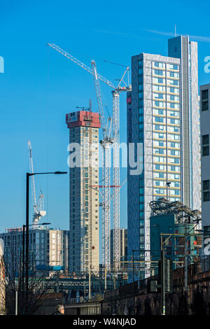 Les carottes de béton et les grues à tour du cercle Square, Oxford Road, Manchester, Angleterre, Royaume-Uni. La liberté vivant de tour à droite. Banque D'Images