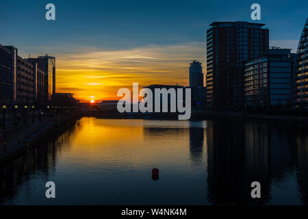 Coucher de soleil sur le bassin du Huron, Salford Quays, Manchester, Royaume-Uni. Appartements Lofts de la ville sur la droite et l'MediaCityUK bâtiments dans la distance. Banque D'Images