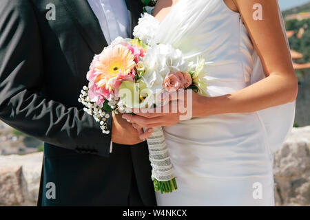 Closeup portrait of Bride and Groom hugging and holding bouquet de mariage en mains, selective focus Banque D'Images