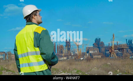 L'homme le travail. projets ingénieur Journée ensoleillée et les nuages. L'homme est vêtu d'un gilet lunettes vert Banque D'Images