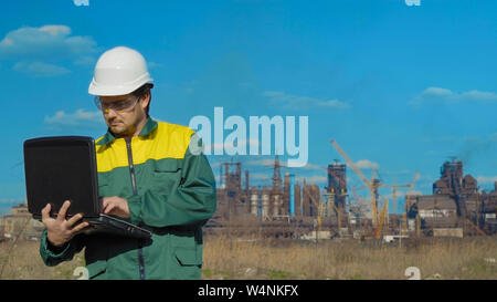 L'homme le travail. projets ingénieur Journée ensoleillée et les nuages. L'homme est vêtu d'un gilet lunettes vert Banque D'Images