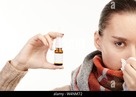 Portrait d'une femme malade en beige sweater holding spray. Banque D'Images