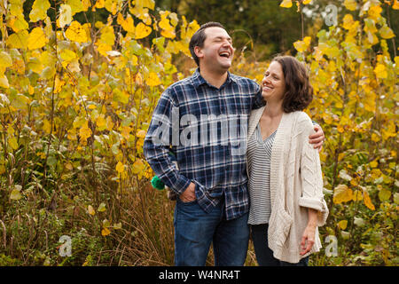 Un rire couple stand à embrasser dans une prairie d'or Banque D'Images