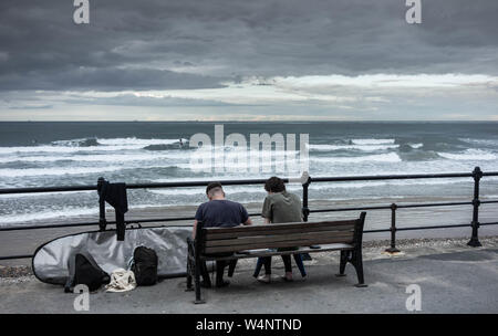 La consommation de poisson et les surfeurs de jetons à Saltburn by the sea, North Yorkshire, Angleterre. UK Banque D'Images