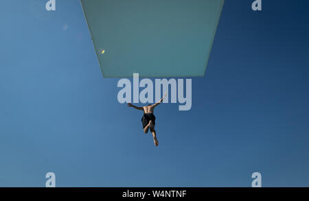 Bielefeld, Allemagne. 24 juillet, 2019. Un nageur passe de la tour de 10 mètres dans une piscine extérieure. Credit : Friso Gentsch/dpa/Alamy Live News Banque D'Images
