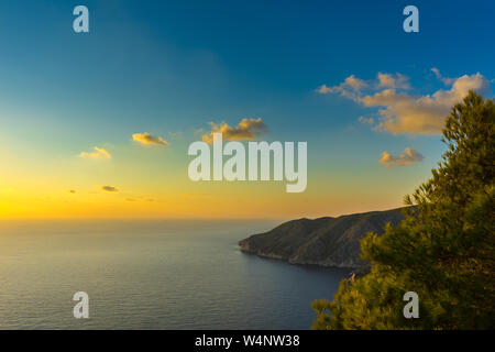 Grèce, Zante, orange romantique coucher de soleil sur l'océan bleu sans fin et de belles falaises de la côte Banque D'Images