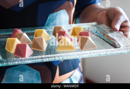 Chocolat pralines vegan colorés en verre sur plateau. Banque D'Images