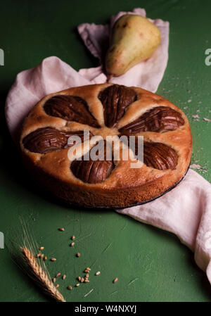 Gâteau aux fruits traditionnel avec des poires entières sur un fond vert. Dessert de saison faits maison. Banque D'Images