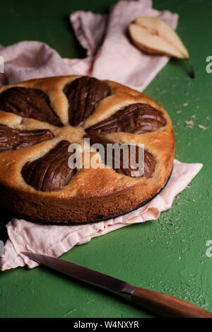 Accueil-poire cuite gâteau sur une serviette de cuisine. Délicieux dessert avec fruits poire entière. Recette un aliment sucré italien Banque D'Images