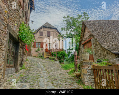 Conques, Midi Pyrénées, France - 31 juillet 2017 : Pierre étroite typique street dans le village de Conques décoré avec des plantes et des fleurs dans leur chambre Banque D'Images